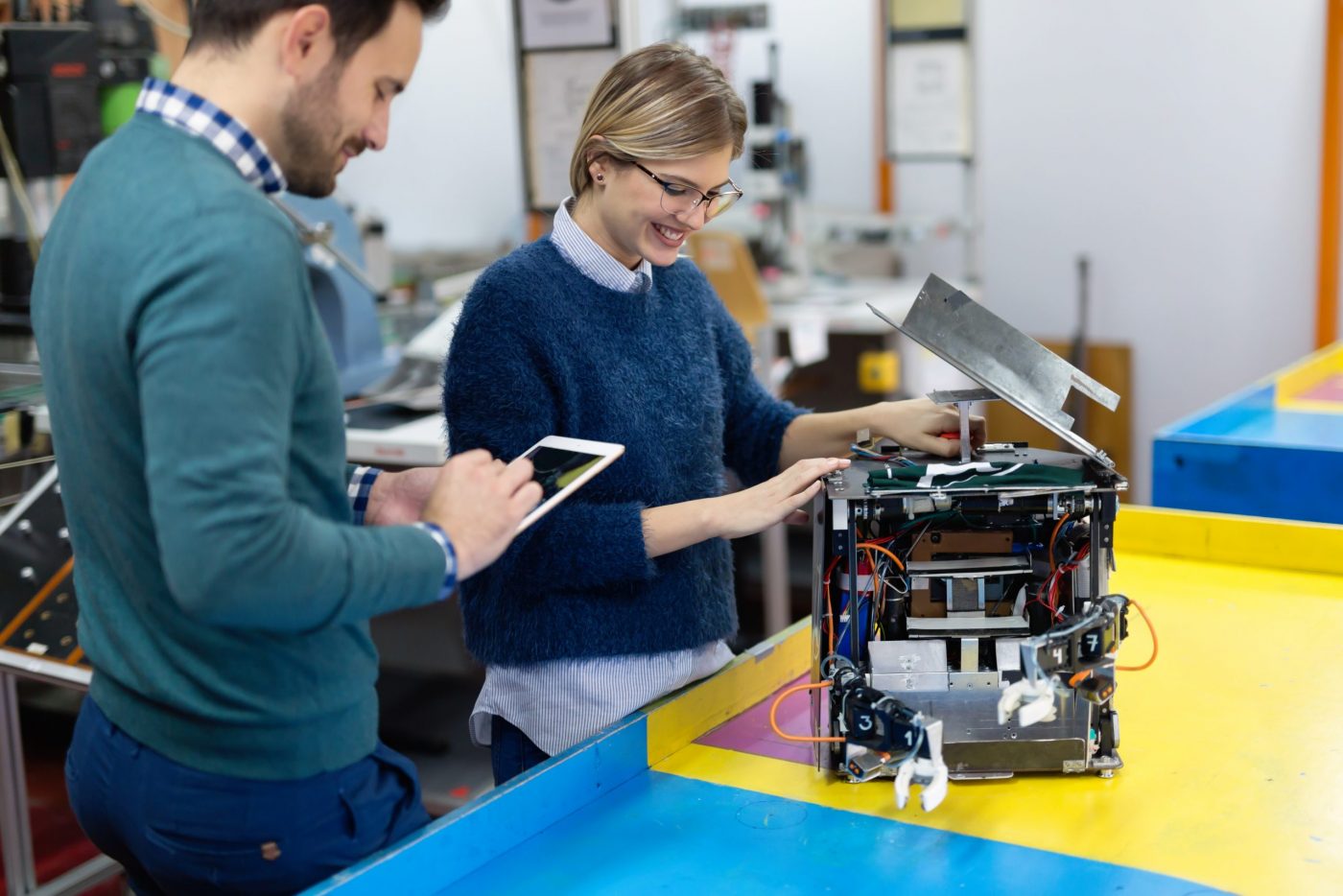 Young students of robotics preparing robot for testing