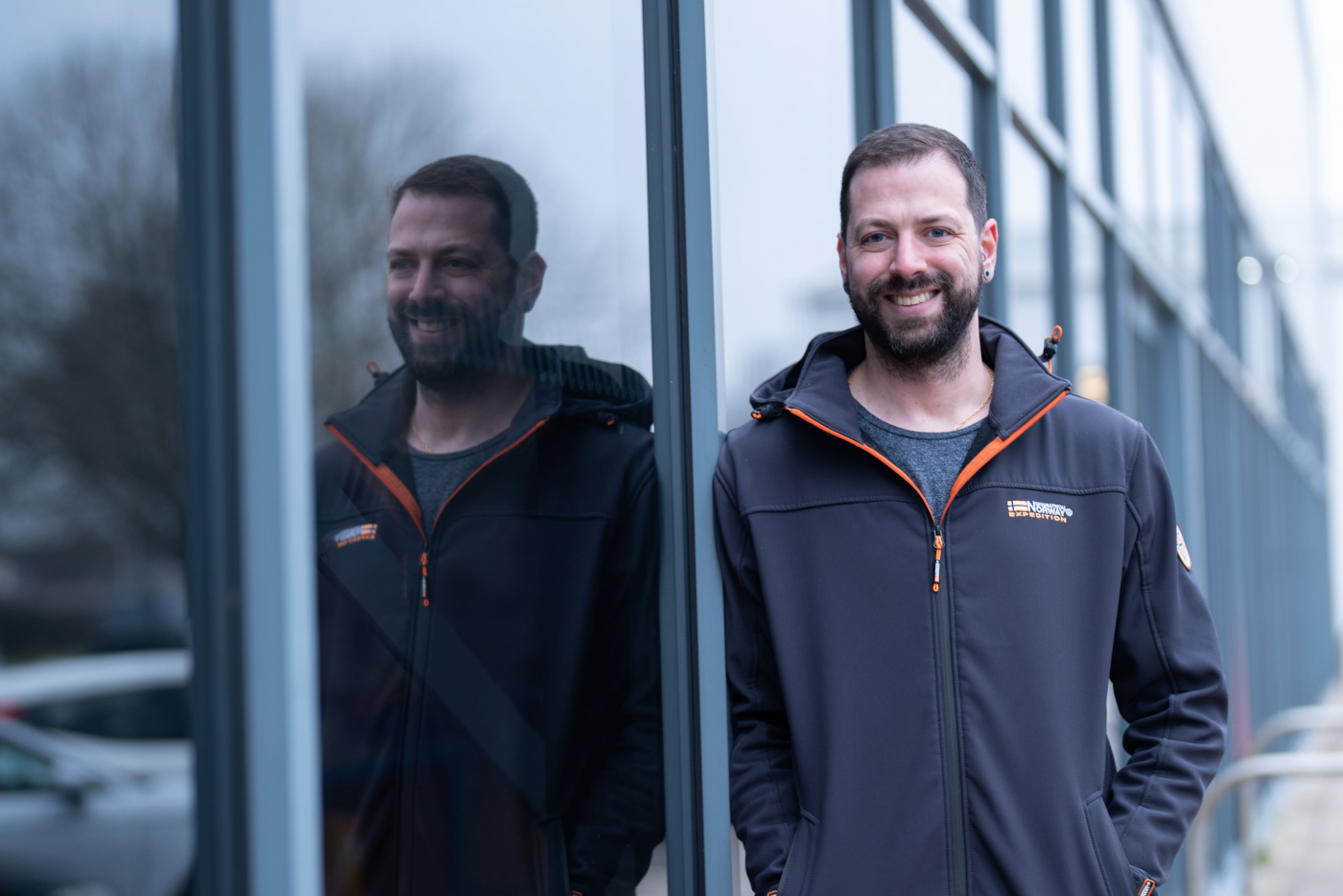 Bruno leaning against glass building