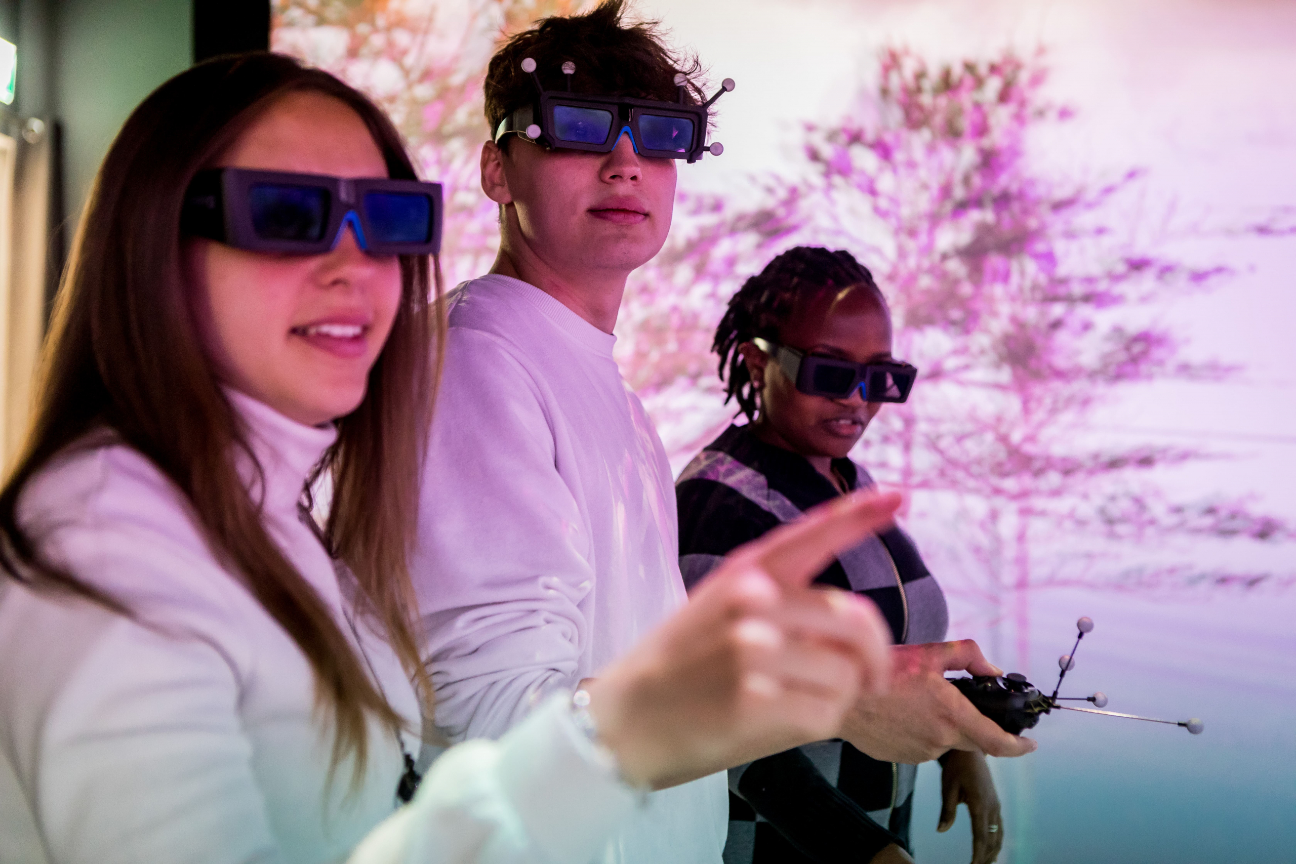 2 girls and a boy using tech glasses