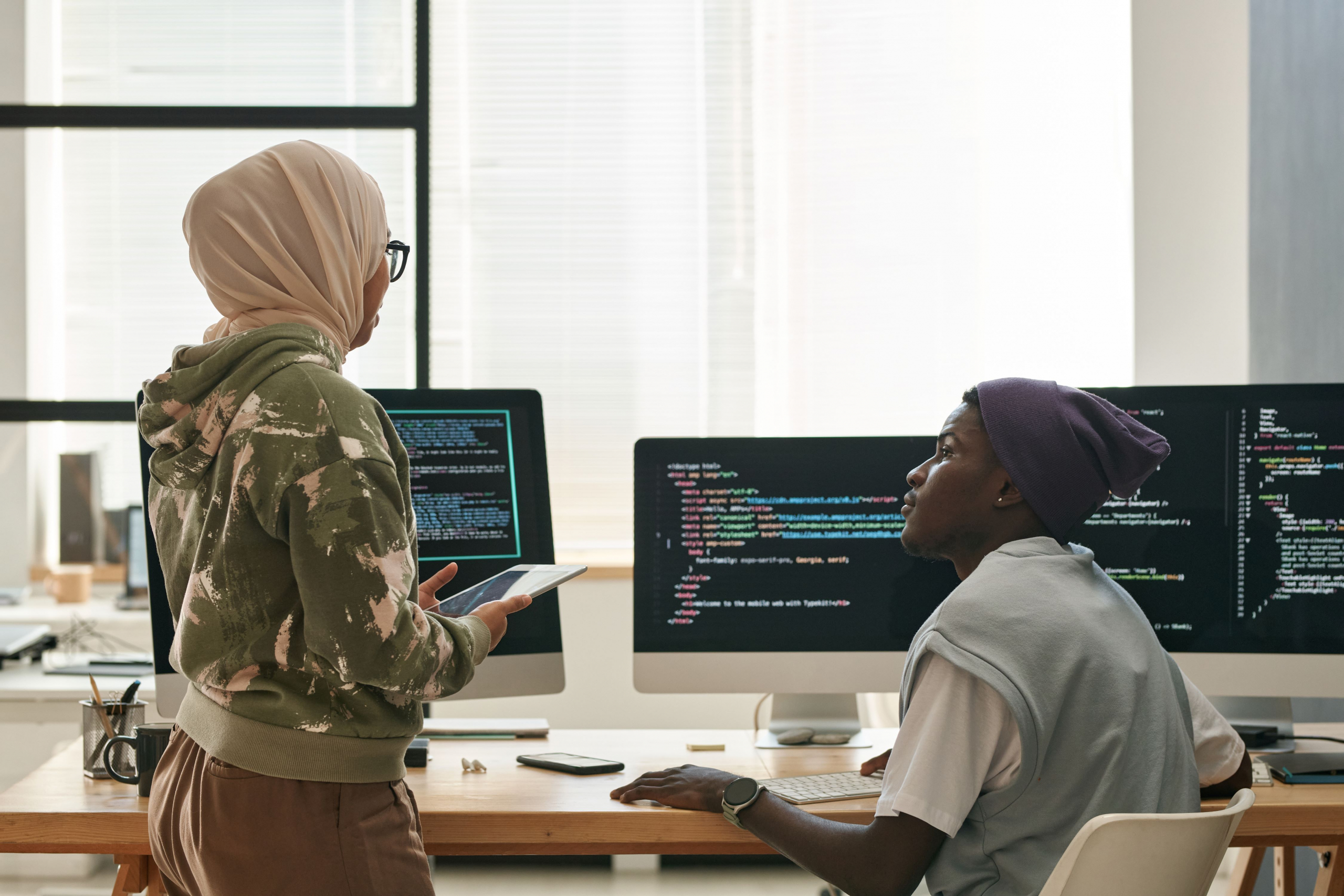 Two young IT engineers discussing ways of decoding data